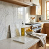White marble cutting board with subtle gray veining resting on countertop made of oriental white asian statuary marble 6x6 polished or honed