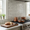 Set of copper cookware with stainless steel lids and handles arranged on gas stove with oriental white asian statuatory mosaic