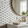 Gold-finished round mirror with minimalist frame above oriental white asian statuary marble mosaic sink countertop