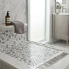 A sleek modern shower floor with glossy white and gray oriental white marble penny-round mosaic tiles