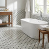 White freestanding bathtub with sleek modern design featuring oriental white asian statuary stanza mosaic marble tiles