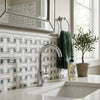 Chrome-finished kitchen faucet with sleek curved spout paired with oriental white asian statuary marble mosaic surface