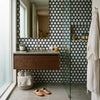 Modern floating wooden vanity with sleek concrete countertop and gold-toned faucet featuring oriental white asian statuary vortex 2 inch hexagon tile with black marble mosaic polished finish
