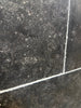 Pietra Notte Marble 16x24 tile with black surface, white grout, speckled texture