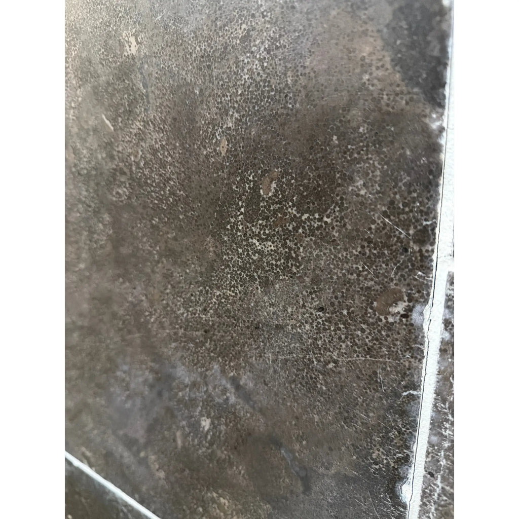 Dark gray Pietra Notte Marble 16x24 tile with mottled concrete texture and edge cracks