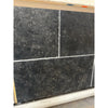 Dark gray Pietra Notte Marble 16x24 tile with textured speckled surface and white grout