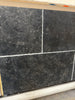 Dark gray Pietra Notte Marble 16x24 tile with textured speckled surface and white grout