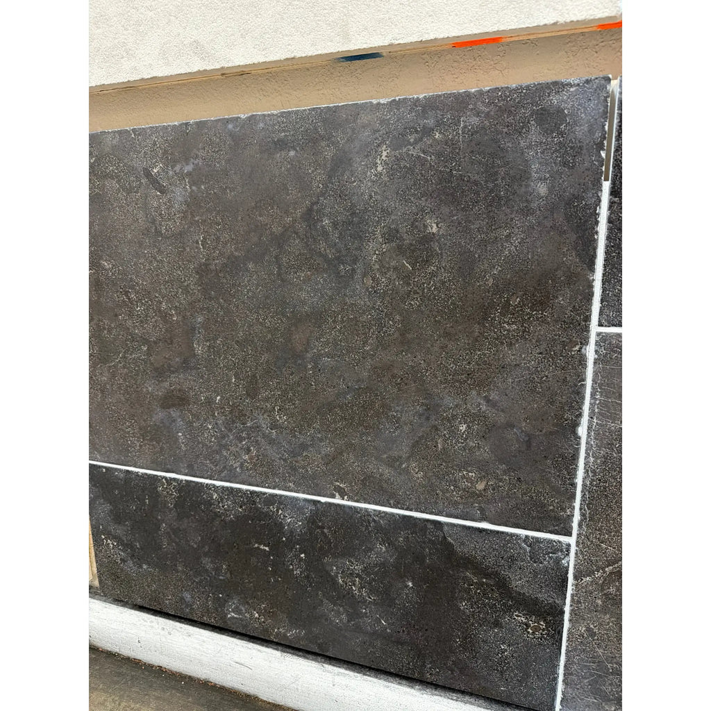 Dark gray Pietra Notte Marble 16x24 tile with mottled texture and white grout