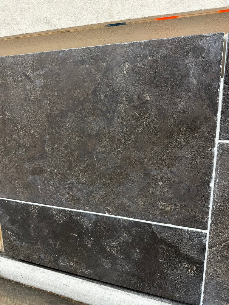 Dark gray Pietra Notte Marble 16x24 tile with mottled texture and white grout