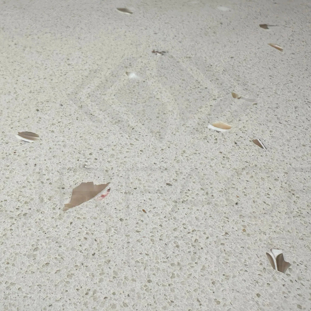 Speckled Riviera Quartz countertop with scattered debris in polished tile display