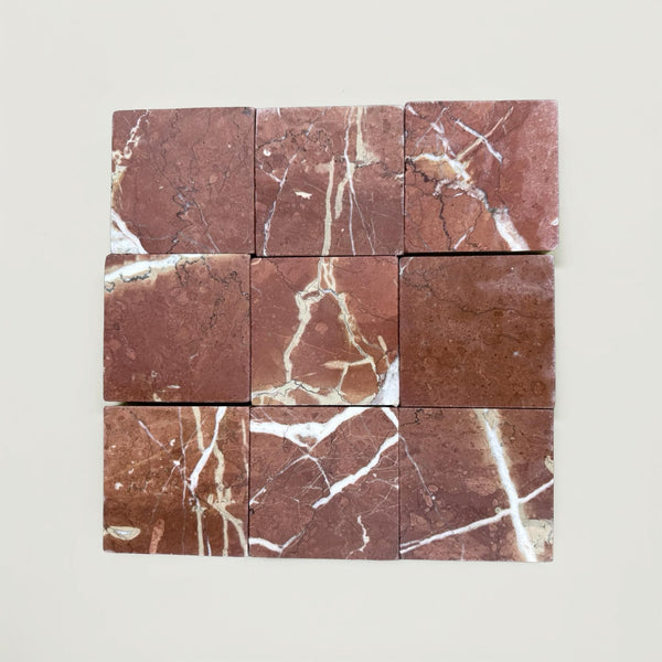 Nine reddish-brown Rojo Alicante 4X4 Tumbled marble tiles with white veining