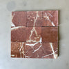 Nine red marble tiles with prominent white veins in a tumbled finish for Rojo Alicante 4X4