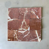 Nine red marble tiles with prominent white veins in a tumbled finish for Rojo Alicante 4X4