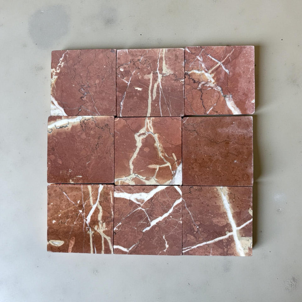 Nine red marble tiles with prominent white veins in a tumbled finish for Rojo Alicante 4X4