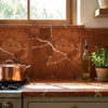 Copper pot with lid and two handles on stovetop placed on rojo alicante marble 12x12 honed-polished tile surface