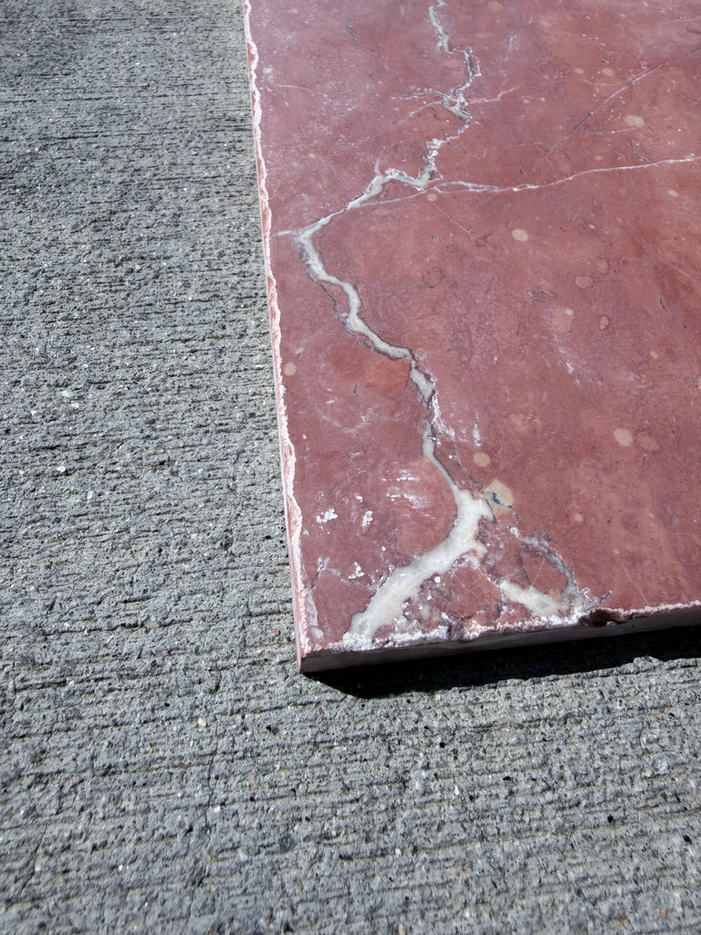 Rojo Alicante Rustic Modern Tumbled reddish-pink marble tile with white veining on gray concrete