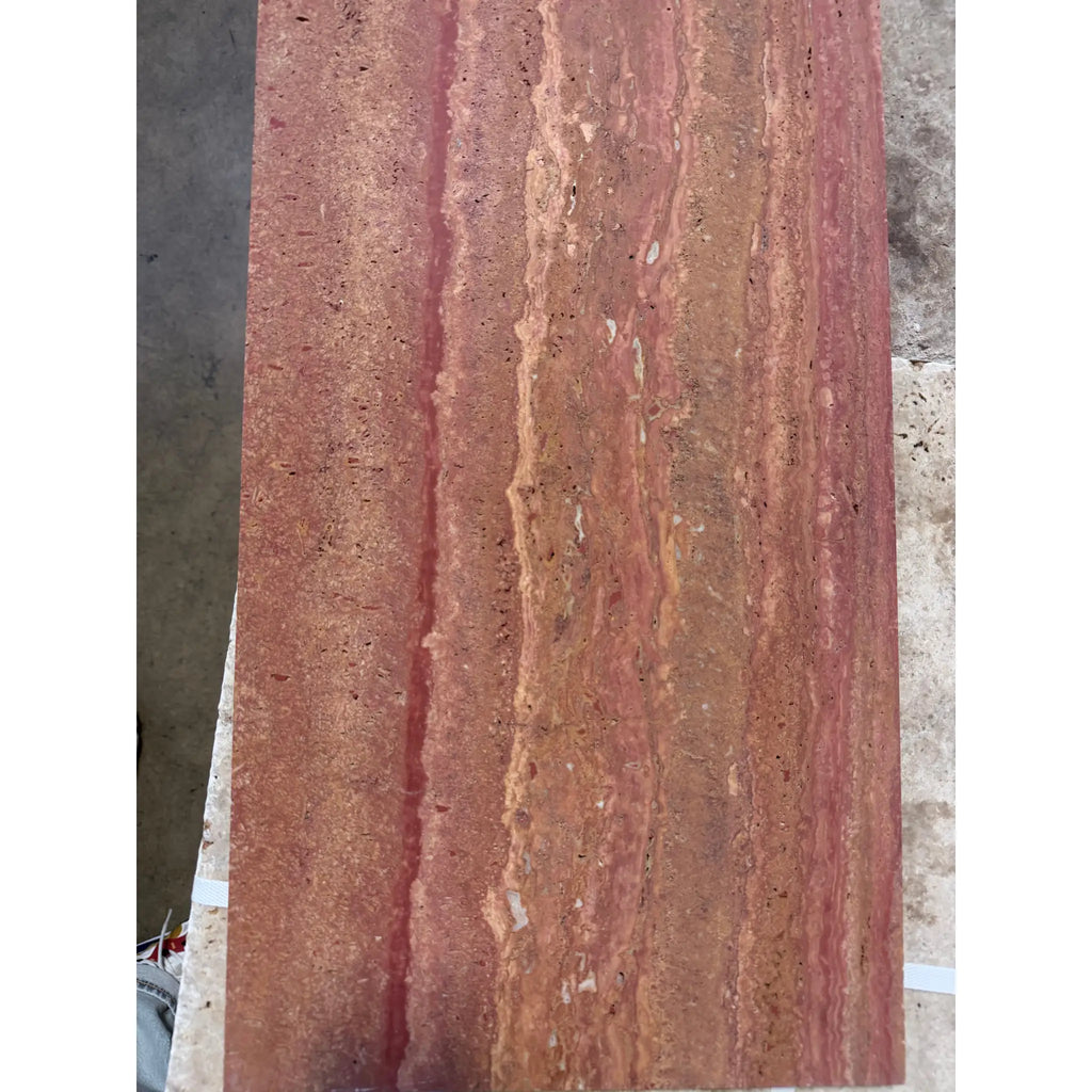 A rectangular slab of rojo red vein-cut travertine stone in 12x24 size with filled polished and honed finish