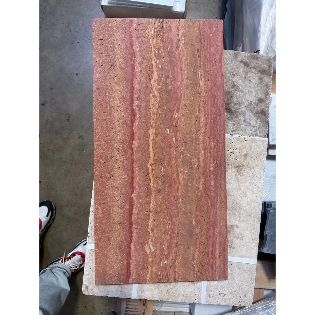 A rectangular slab of rojo red vein-cut travertine stone with natural wavy veining and a polished honed surface