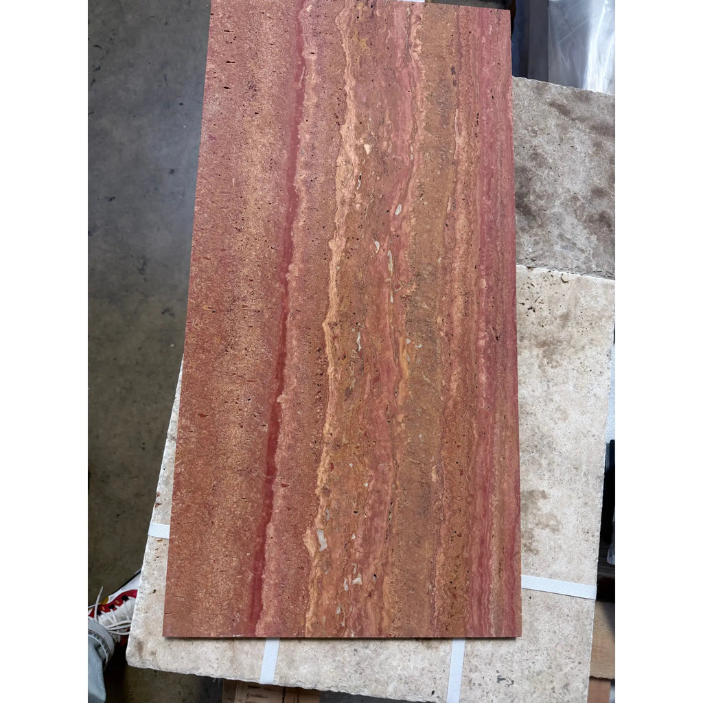 A rectangular slab of rojo red vein cut travertine stone with natural vertical veining and a polished honed finish