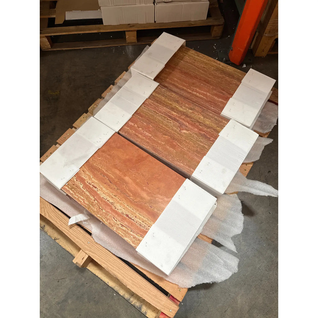 Stacked orange and red travertine tiles with natural bands, secured with white strapping