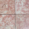 Four pink and white Rosé Aurora Marble 12x12 polished tiles with natural veining and cracks