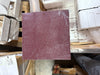Maroon sandpaper sheet with coarse texture and white scuff marks for Rosso Laguna Marble