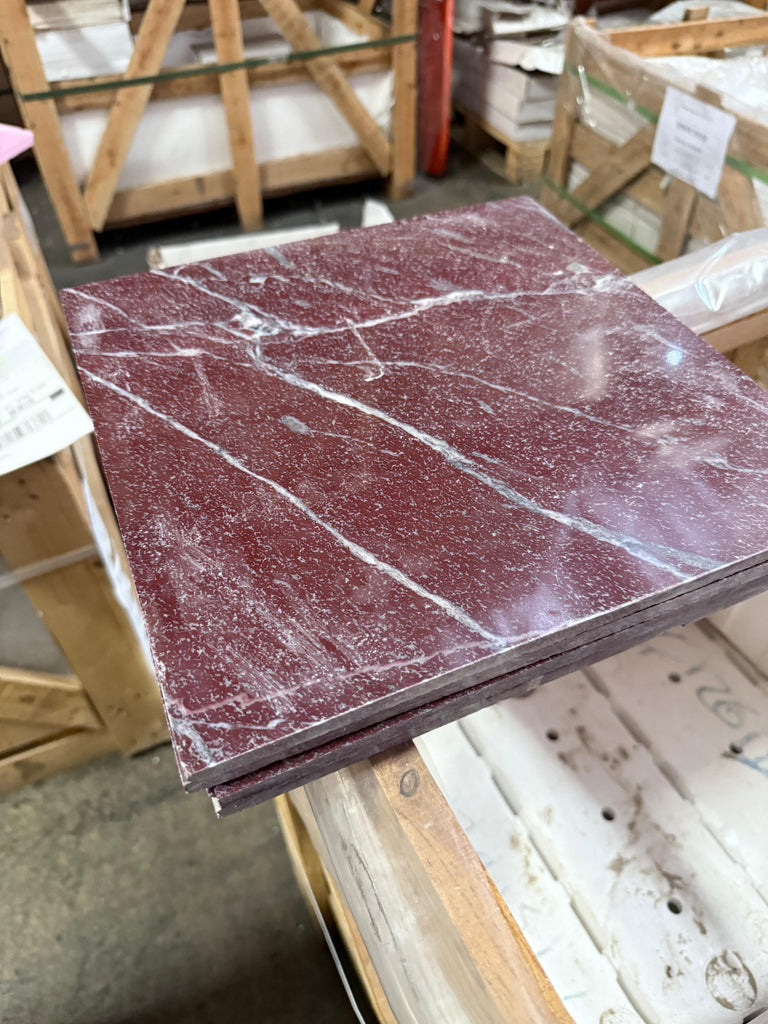 Polished Dark Red Rosso Laguna Marble tiles with white veins stacked neatly