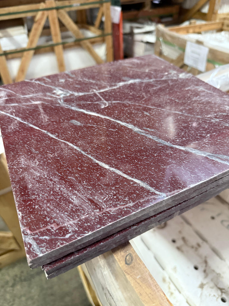 Stack of polished rectangular Rosso Laguna Marble tiles with white veining
