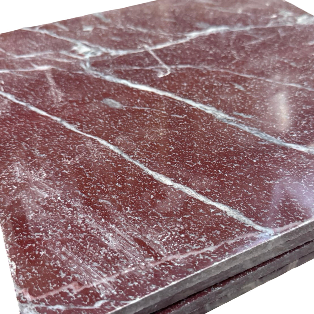 Stacked polished rectangular Rosso Laguna Marble tiles with white veining on a deep red background