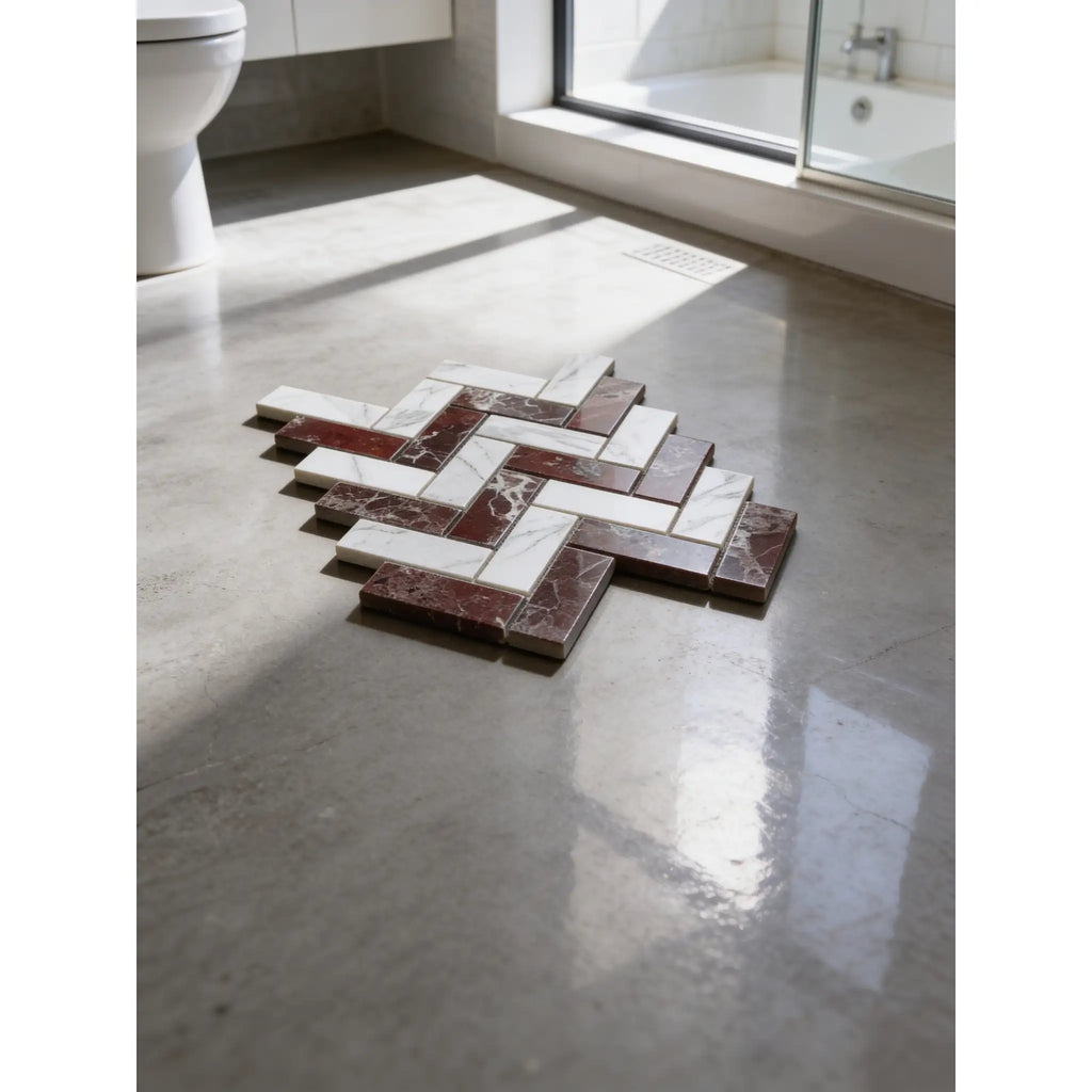 A herringbone mosaic marble floor in white italian statuary and deep red rosso levanto polished-honed tiles