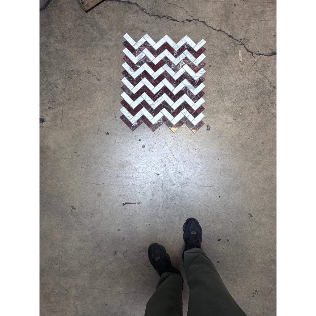 A rectangular polished-honed herringbone mosaic marble panel featuring a bold zigzag pattern in rosso levanto and italian statuary colors
