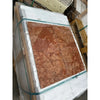 Four square terracotta-colored Rosso Verona marble 12x12 tumbled stone tiles with natural mottled texture in foam packaging