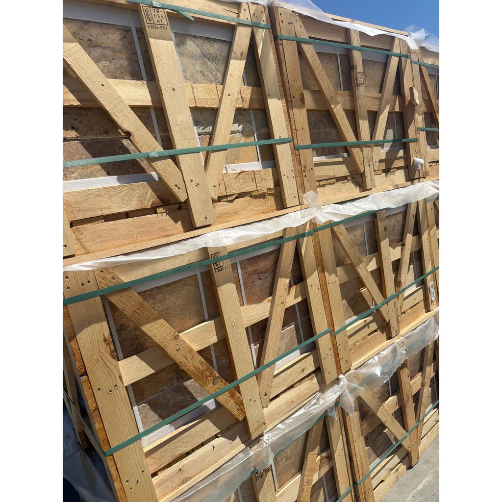 Stacked wooden pallets with diagonal bracing secured by green straps holding scabos autumn leaves travertine 4 pcs set