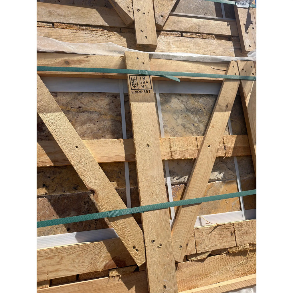 Light brown wooden structural beam with visible grain and knots secured by green straps in autumn leaves travertine set