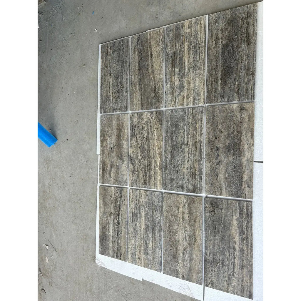 Silver gray travertine 12x24 vein cut tile with natural textured stone effect and filled honed polished finish in grid pattern