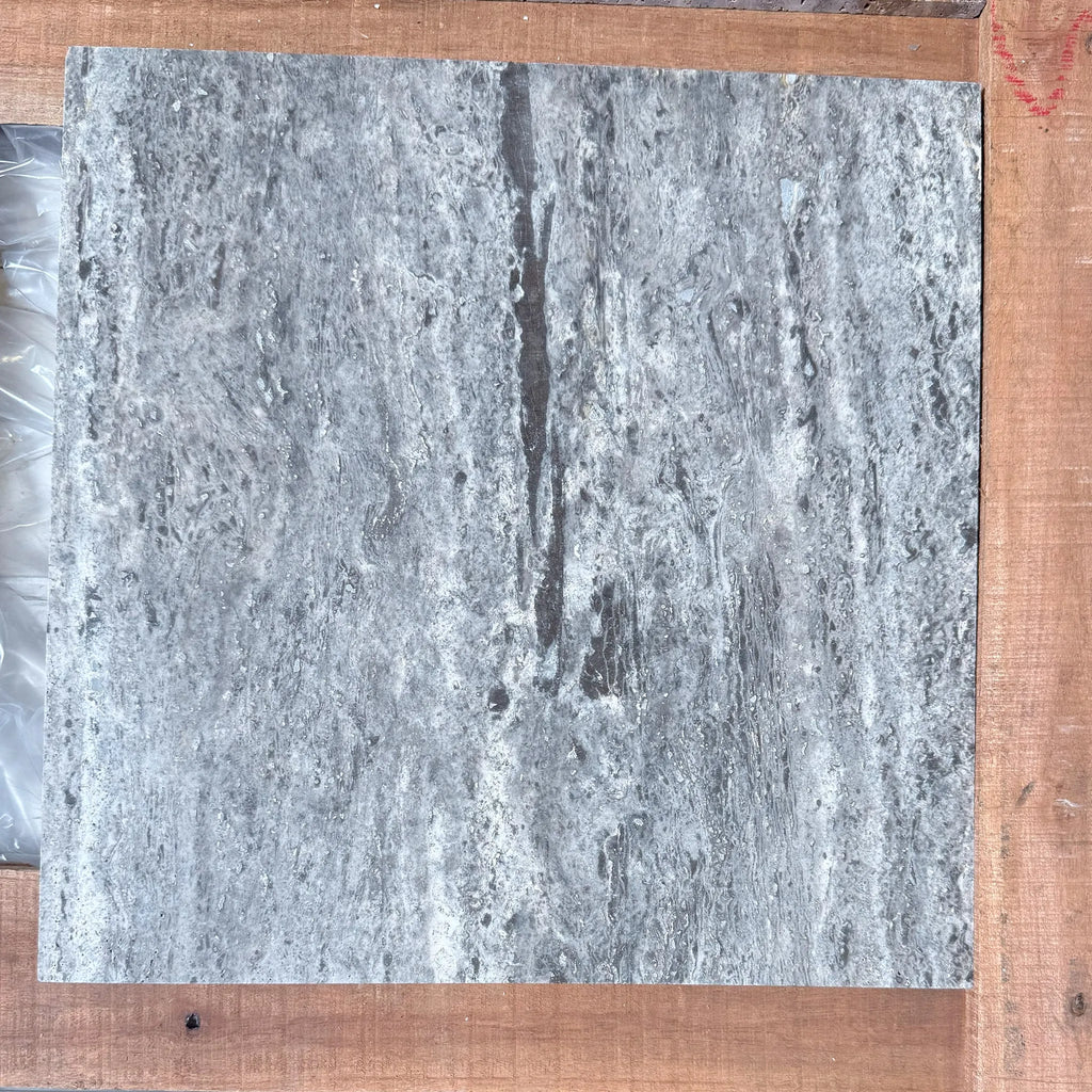 Gray marble tile with dark veining in Silver Travertine 18X18 tile filled and honed