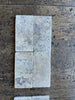 White rectangular Tumbled Travertine 3x6 tiles with a slightly worn texture