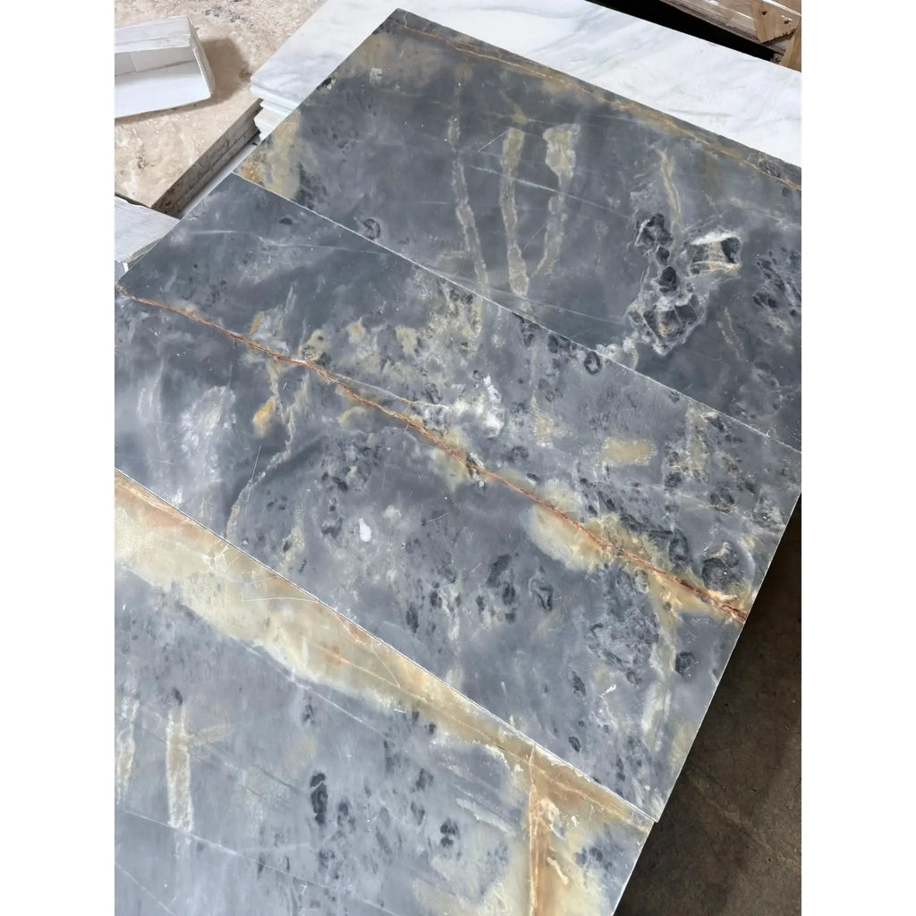Gray marble slabs with gold veining in Sky Blue Azul Cielo 12X24 Marble Tile
