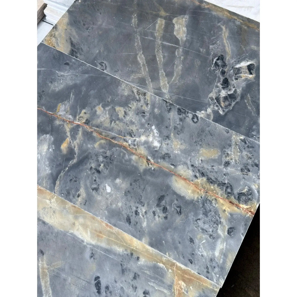 Gray marble slabs with gold veining featured in Sky Blue Azul Cielo 12X24 Marble Tile