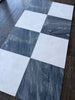 Checkerboard pattern of white and dark gray marble tiles from Sky Blue Azul Cielo 18X18 collection