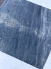 Polished dark gray marble slab with white veining and darker inclusions for Sky Blue Azul Cielo tile