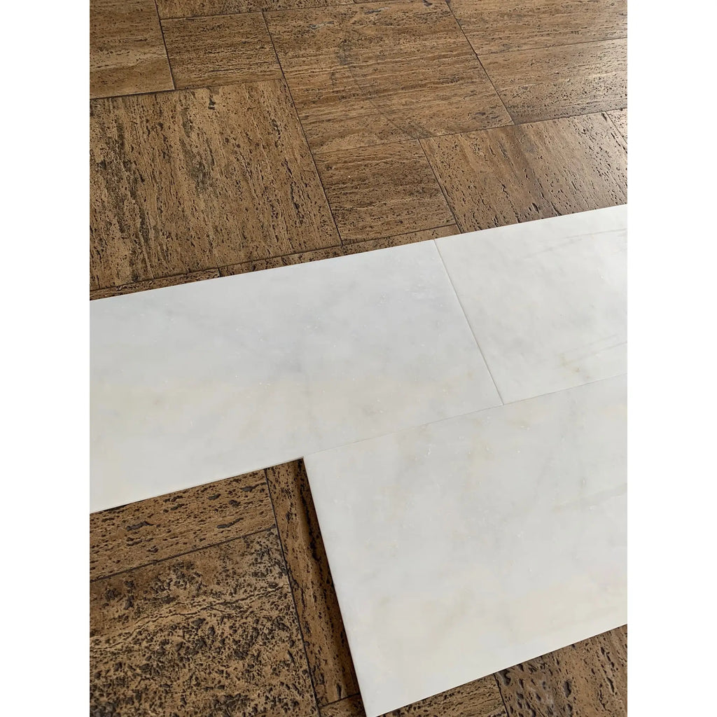 Snow White Marble 12x24 polished tiles on brown cork floor