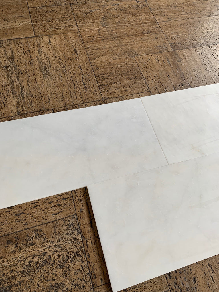 Snow White Marble 12x24 polished tiles on brown cork floor