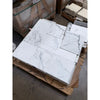 White marble effect statuario 12x12 floor tiles with gray veining stacked on a wooden pallet for premium Italian use
