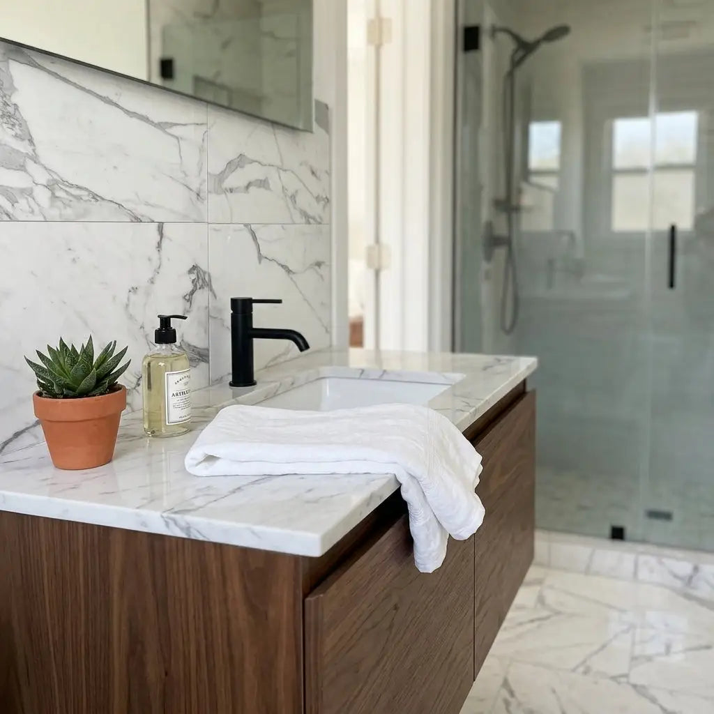 White towel draped over the edge of a polished statuario white 12x12 premium italian marble countertop