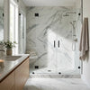 Modern glass shower enclosure with black hardware and statuario white marble patterned walls in premium italian marble