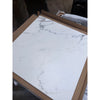 Statuario white 24x24 premium italian marble polished tile with subtle gray veining framed in light brown cardboard