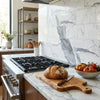 A golden-brown artisan loaf on a rustic wooden board showcasing statuariostatuary white 6x12 premium italian marble polished or honed