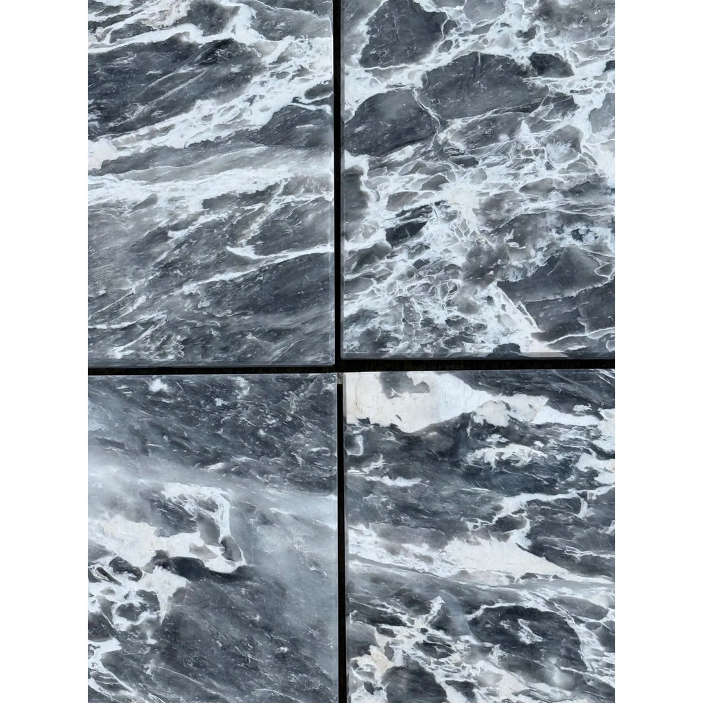Four dark gray marble tiles with striking white veining for Storm Gray Marble 12X12 Polished