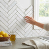 Thassos white 1x4 herringbone mosaic polished marble tiles in white used as a kitchen backsplash